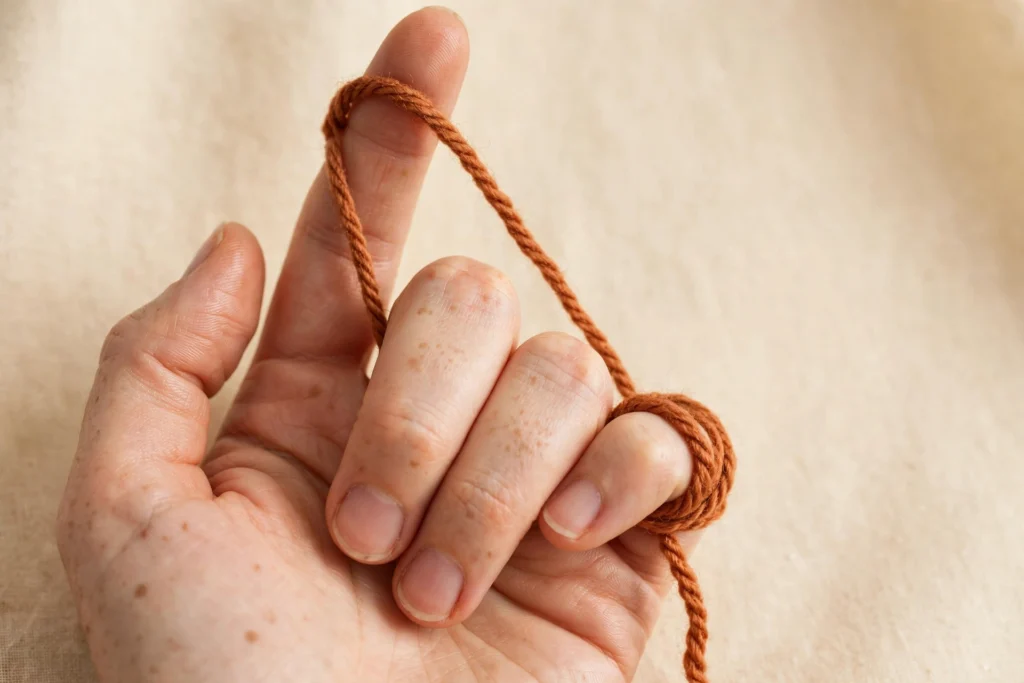 Yarn draped over the index finger for crochet tension